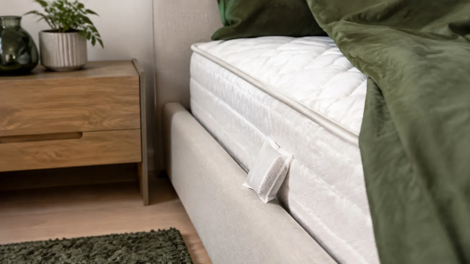 Silicagelzakje naast een matrasnaad in een slaapkamer